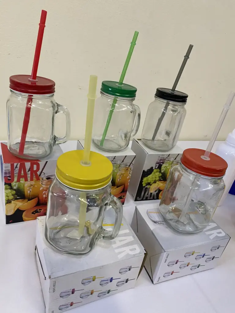 transparent drink bottles with different colour in lids and starws and a box